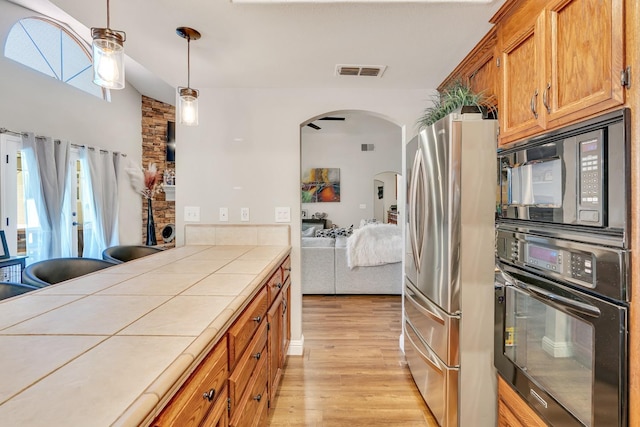 22 Pointe W, Madera, CA 93637 - kitchen with black oven, tile countertops, freestanding refrigerator, built in microwave, and arched walkways