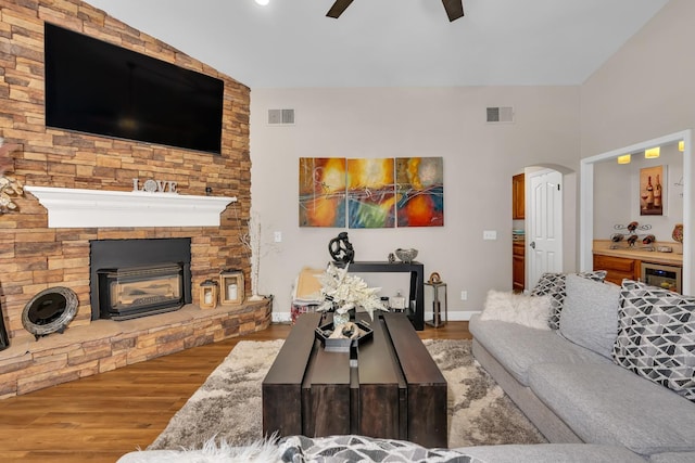 22 Pointe W, Madera, CA 93637 - living room with ceiling fan, wine cooler, wood finished floors, arched walkways, and a stone fireplace