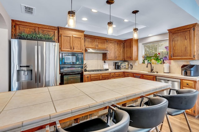 22 Pointe W, Madera, CA 93637 - kitchen featuring black appliances, a sink, under cabinet range hood, backsplash, and brown cabinetry