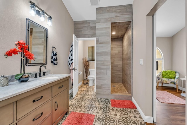 22 Pointe W, Madera, CA 93637 - bathroom featuring toilet, vanity, tiled shower, baseboards, and wood finished floors