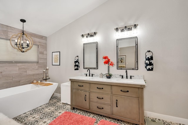 22 Pointe W, Madera, CA 93637 - bathroom featuring baseboards, a freestanding tub, a chandelier, and double vanity