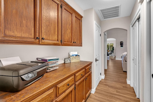 22 Pointe W, Madera, CA 93637 - hallway featuring arched walkways, light wood finished floors, baseboards, and a desk