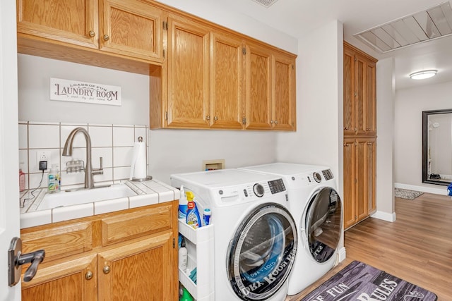 22 Pointe W, Madera, CA 93637 - washroom featuring washing machine and dryer, cabinet space, light wood finished floors, and baseboards