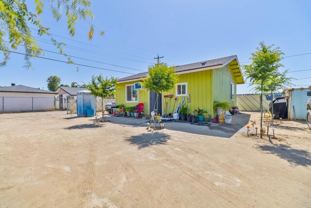 1197 Pucheu St, Mendota, CA 93640 - back of house with an outdoor structure, a shed, fence, and board and batten siding