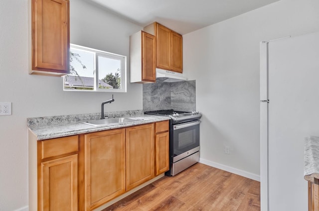 1197 Pucheu St, Mendota, CA 93640 - kitchen featuring gas stove, under cabinet range hood, a sink, light wood finished floors, and freestanding refrigerator