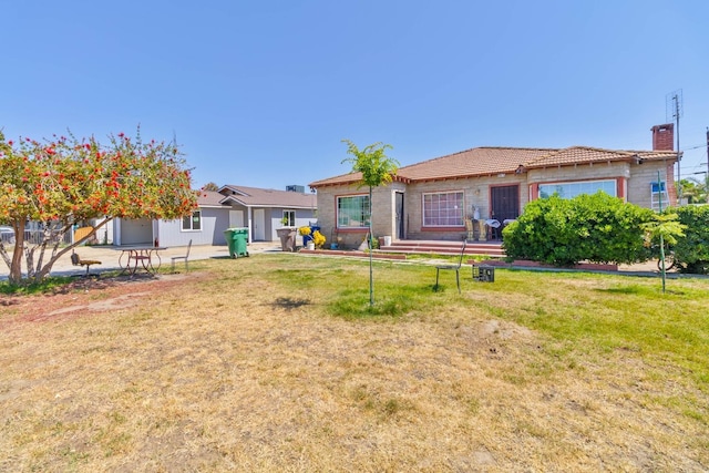 1197 Pucheu St, Mendota, CA 93640 - rear view of house featuring a chimney and a lawn