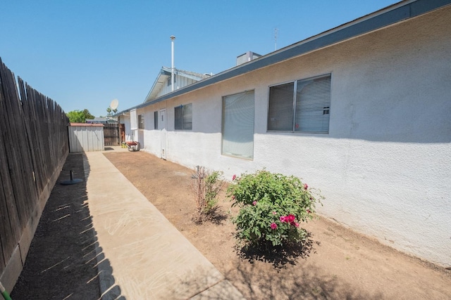 view of home's exterior with fence and stucco siding