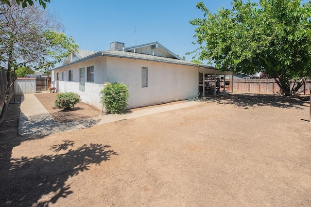 rear view of house with a fenced backyard and stucco siding