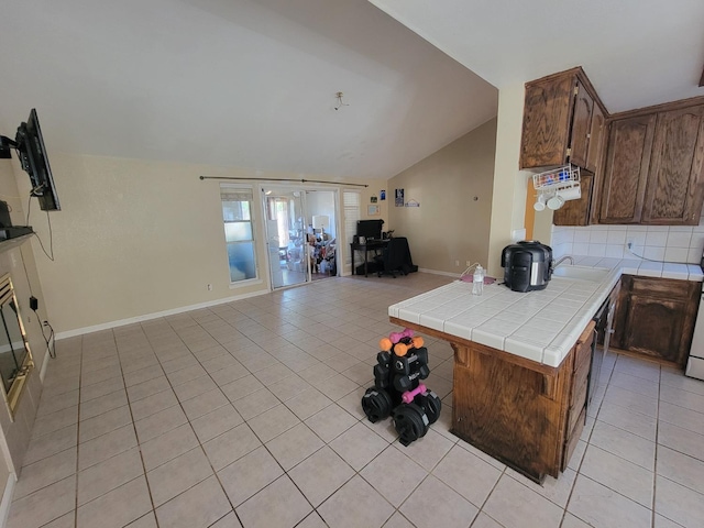 5566 W Fir Ave, Fresno, CA 93722 - kitchen with tile countertops, open floor plan, light tile patterned floors, vaulted ceiling, and a sink