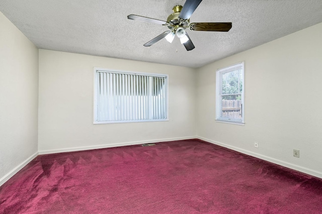 empty room with carpet floors, a textured ceiling, baseboards, and ceiling fan