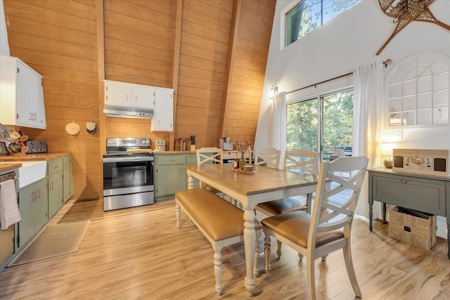 30830 Old Strawberry Rd, Tuolumne, CA 95375 - dining room with healthy amount of natural light, a high ceiling, wood walls, and light wood finished floors