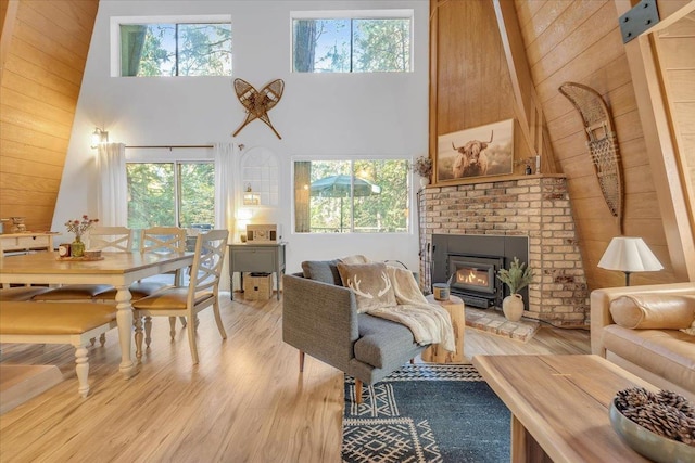 30830 Old Strawberry Rd, Tuolumne, CA 95375 - living room with a towering ceiling, light wood-style floors, plenty of natural light, wooden walls, and a wood stove
