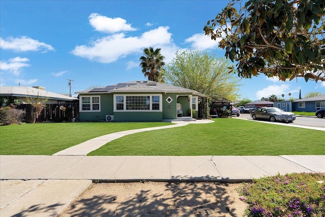 view of front of home featuring solar panels and a front yard