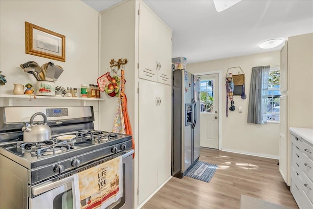 kitchen with stainless steel gas stove, refrigerator with ice dispenser, healthy amount of natural light, and light wood-type flooring