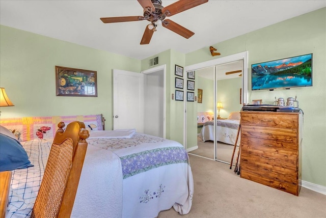 carpeted bedroom featuring a closet, baseboards, and a ceiling fan