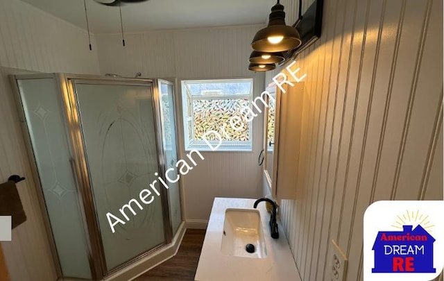 bathroom featuring a stall shower, wood finished floors, and vanity