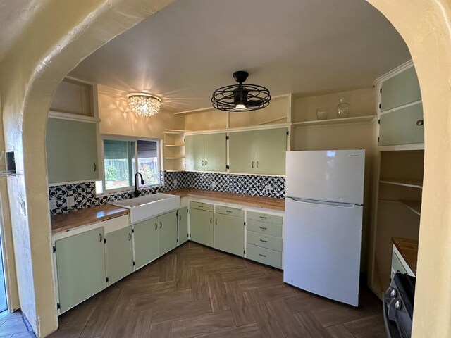 1441 N Calaveras St, Fresno, CA 93728 - kitchen with open shelves, freestanding refrigerator, a ceiling fan, decorative backsplash, and arched walkways