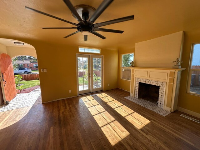 1441 N Calaveras St, Fresno, CA 93728 - unfurnished living room featuring wood finished floors, a tiled fireplace, a ceiling fan, and french doors