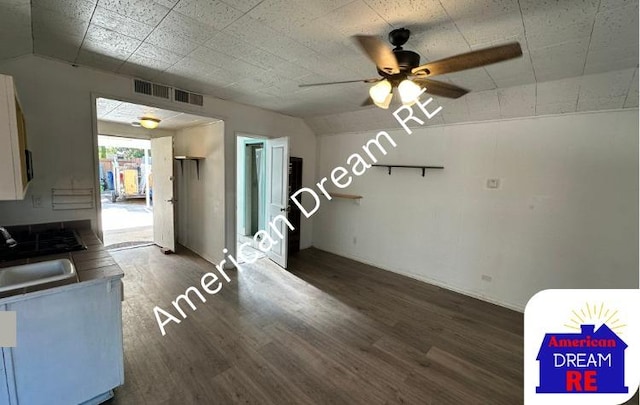 unfurnished dining area with a sink, dark wood-style floors, a ceiling fan, and lofted ceiling
