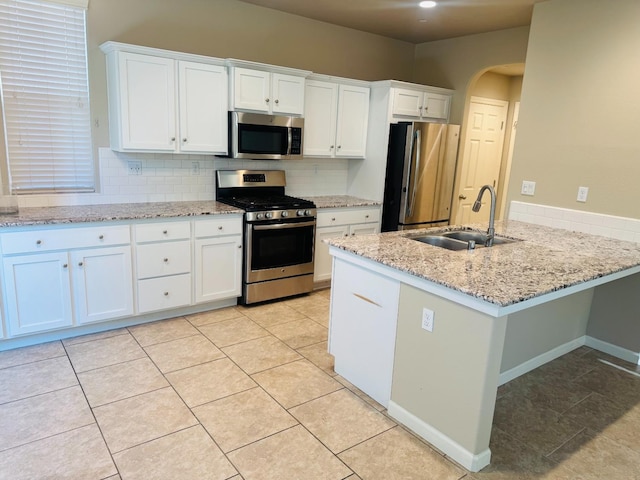 3673 Artistry Way, Clovis, CA 93619 - kitchen with stainless steel appliances, a sink, white cabinetry, and decorative backsplash