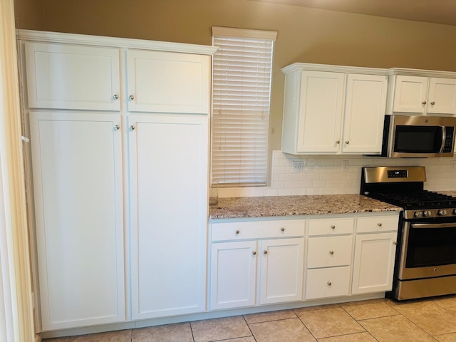 3673 Artistry Way, Clovis, CA 93619 - kitchen with appliances with stainless steel finishes, white cabinets, light stone countertops, and light tile patterned floors