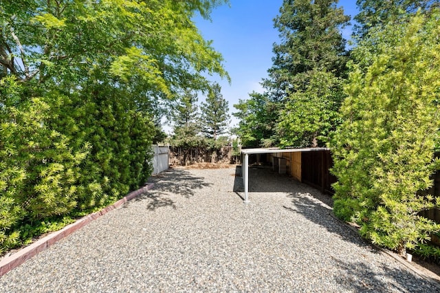 10597 E Fieldstone Ave, Clovis, CA 93619 - view of yard featuring fence, gravel driveway, and a carport
