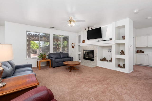 10597 E Fieldstone Ave, Clovis, CA 93619 - carpeted living area featuring a fireplace, a ceiling fan, built in shelves, rail lighting, and baseboards