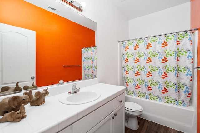 10597 E Fieldstone Ave, Clovis, CA 93619 - bathroom featuring wood finished floors, toilet, vanity, and shower / bathtub combination with curtain