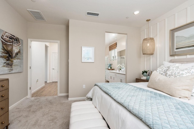 bedroom with carpet flooring, baseboards, and connected bathroom