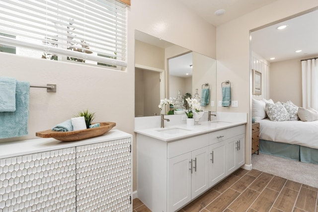 bathroom with wood finished floors, double vanity, recessed lighting, and ensuite bath