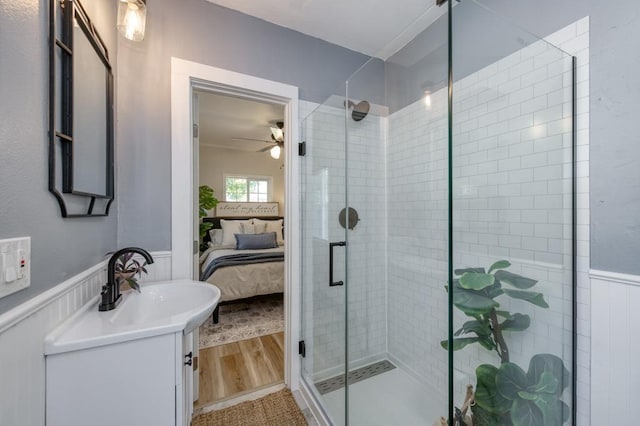 3443 E Washington Ave, Fresno, CA 93702 - ensuite bathroom with a wainscoted wall, a stall shower, a ceiling fan, and vanity