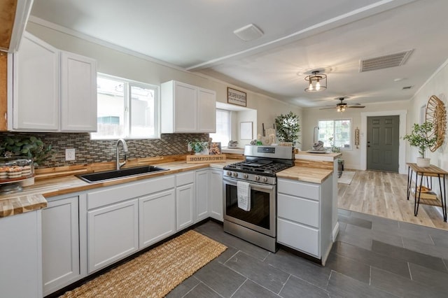 3443 E Washington Ave, Fresno, CA 93702 - kitchen featuring butcher block counters, stainless steel range with gas cooktop, a sink, a peninsula, and decorative backsplash