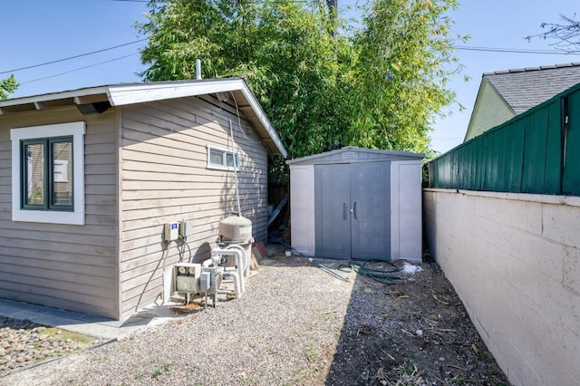 view of home's exterior with an outbuilding, a storage unit, and fence