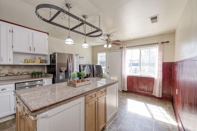 kitchen featuring appliances with stainless steel finishes, a ceiling fan, open shelves, light stone finish flooring, and light countertops