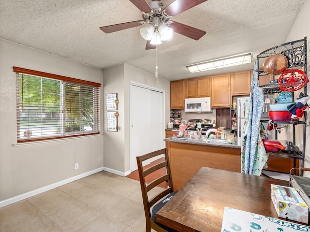 2204 Peach Ave Unit 1, Clovis, CA 93612 - dining area with a textured ceiling, baseboards, a ceiling fan, and light tile patterned flooring