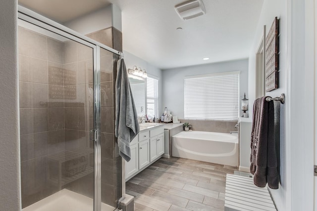 3877 Griffith Ave, Clovis, CA 93619 - bathroom with a bath, vanity, a stall shower, recessed lighting, and wood finished floors