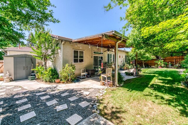 947 Carson Ave, Clovis, CA 93611 - rear view of property with ceiling fan, stucco siding, a patio, a storage shed, and an outbuilding