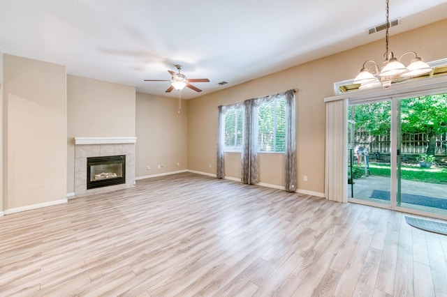 947 Carson Ave, Clovis, CA 93611 - unfurnished living room with wood finished floors, ceiling fan, a tile fireplace, baseboards, and a chandelier