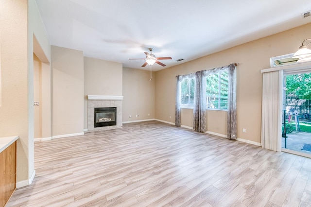 947 Carson Ave, Clovis, CA 93611 - unfurnished living room with light wood-type flooring, a ceiling fan, a tile fireplace, and baseboards