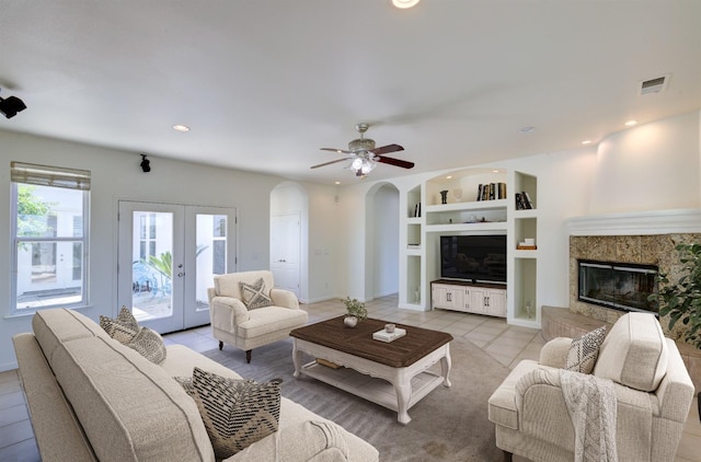 30925 Pennyroyal Ln, Prather, CA 93651 - living area with light tile patterned floors, a high end fireplace, built in features, arched walkways, and french doors