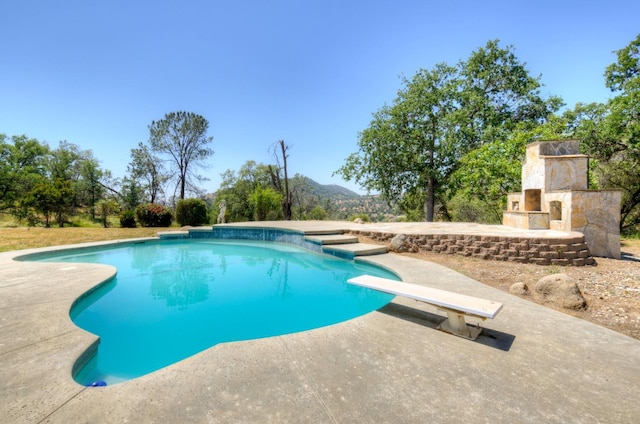 30925 Pennyroyal Ln, Prather, CA 93651 - outdoor pool featuring a patio, a diving board, and an outdoor stone fireplace