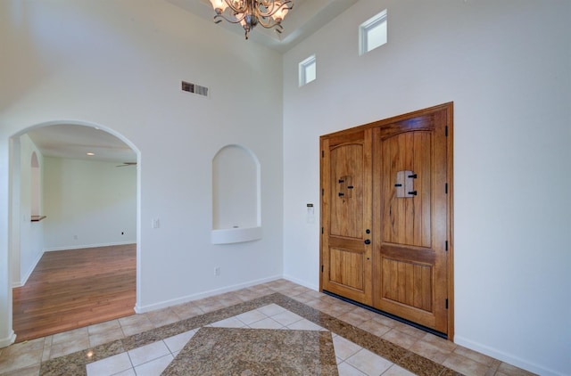 30925 Pennyroyal Ln, Prather, CA 93651 - foyer entrance with a high ceiling, arched walkways, a chandelier, light tile patterned floors, and baseboards