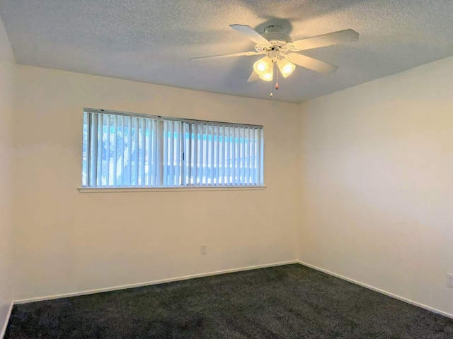 unfurnished room featuring plenty of natural light, dark colored carpet, a textured ceiling, a ceiling fan, and baseboards