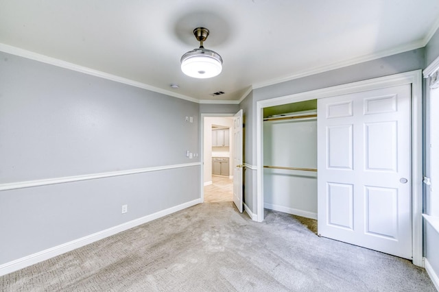unfurnished bedroom featuring carpet flooring, crown molding, baseboards, and a closet