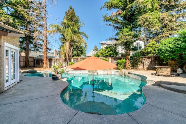 view of pool with a fenced backyard, a patio area, and french doors