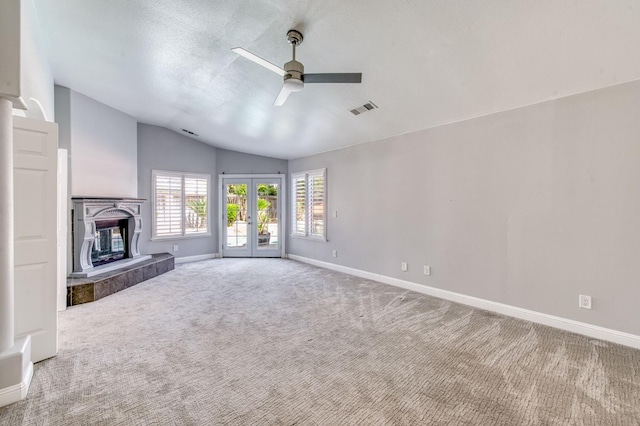unfurnished living room with a ceiling fan, vaulted ceiling, baseboards, and carpet
