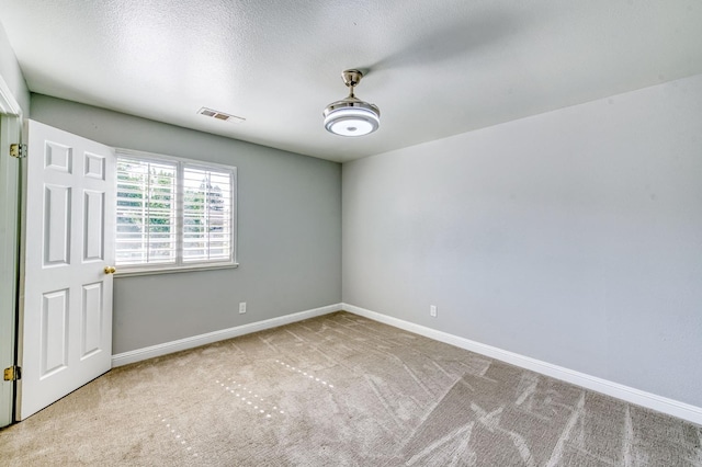 spare room featuring carpet flooring and baseboards