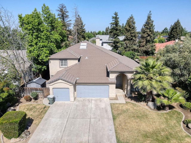 view of front of home featuring a tiled roof, a garage, stucco siding, and concrete driveway