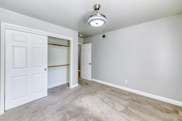 unfurnished bedroom featuring carpet, a closet, and baseboards