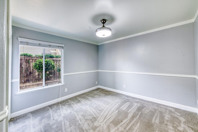 carpeted spare room with crown molding and baseboards